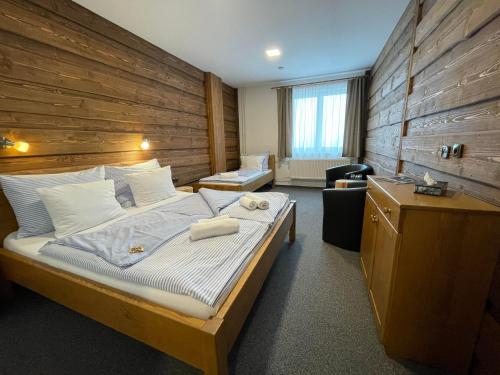 库波瓦霍特Hotel Kristian的一间卧室设有一张带木墙的大床