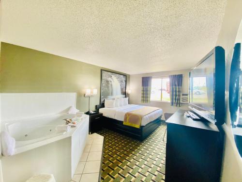 怀俄明Super 8 Grand Rapids City Center的酒店客房配有一张床和浴缸。