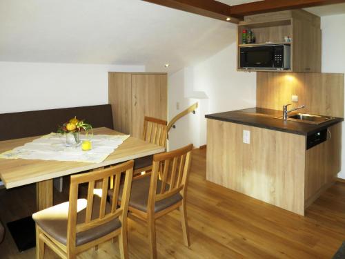 索尔登Apartment Alpenblick - SOE750 by Interhome的厨房配有桌椅和水槽。