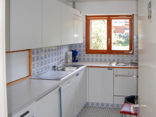 南达Apartment Panoramic G4 by Interhome的厨房配有白色橱柜、水槽和窗户。