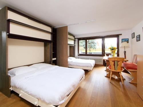 采尔马特Apartment Residence A-1 by Interhome的卧室配有一张白色大床和一张书桌