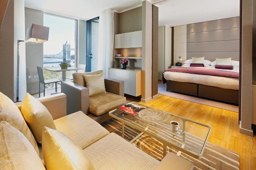伦敦仕骅廷三码头酒店公寓的酒店客房设有床和客厅。