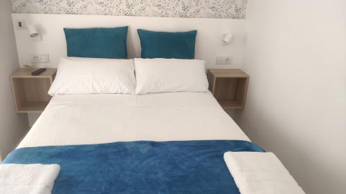 波尔托马林PortoSantiago的一张带蓝色和白色床单及蓝色枕头的床