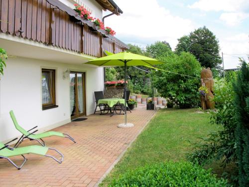 BrendenApartment Alpenblick by Interhome的庭院配有遮阳伞和桌椅。