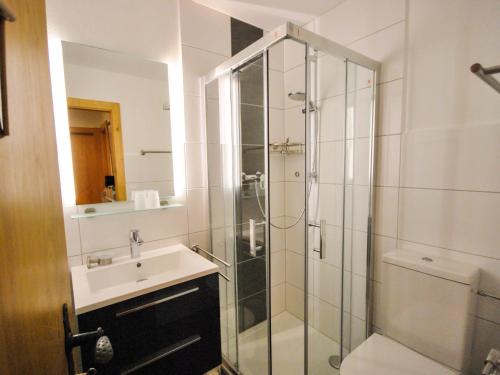 韦松纳博艺莱兹韦松纳公寓的一间带玻璃淋浴和水槽的浴室
