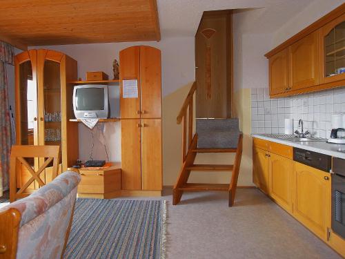 PankrazbergApartment Untererhof-1 by Interhome的厨房配有木制橱柜、电视和沙发。