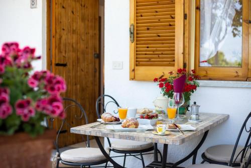 特罗佩阿HibiscusUno Tropea Residence的一张桌子,上面有早餐食品,上面有鲜花