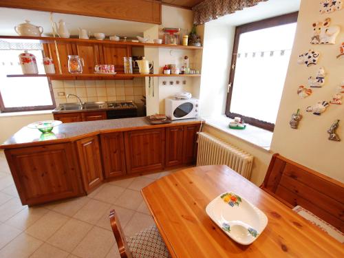 普雷达佐Apartment Garibaldi by Interhome的厨房配有木桌和木桌四柱四柱床