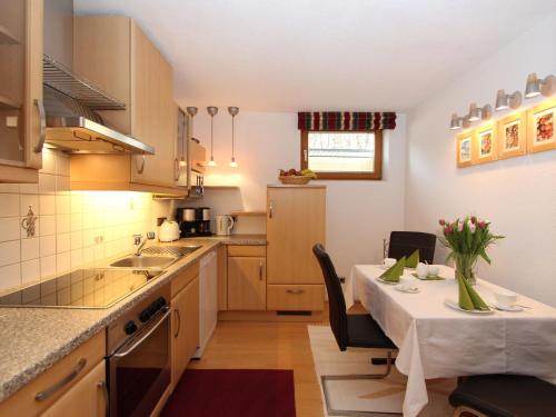 Flaurling哈格勒公寓的厨房以及带桌椅的用餐室。