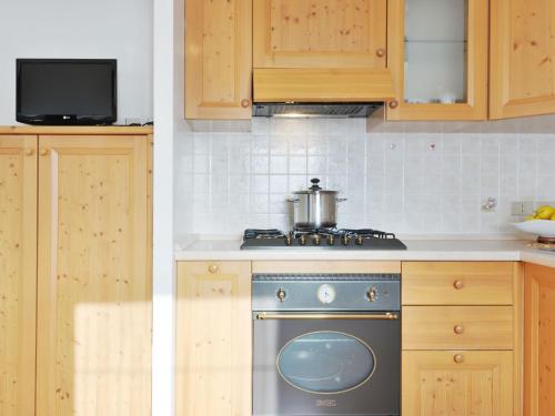 坎皮泰洛Apartment Lazzer-2 by Interhome的厨房配有木制橱柜和炉灶烤箱。