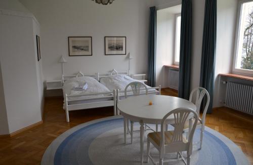 图青图青新教学院酒店的卧室配有一张床和一张桌子及椅子