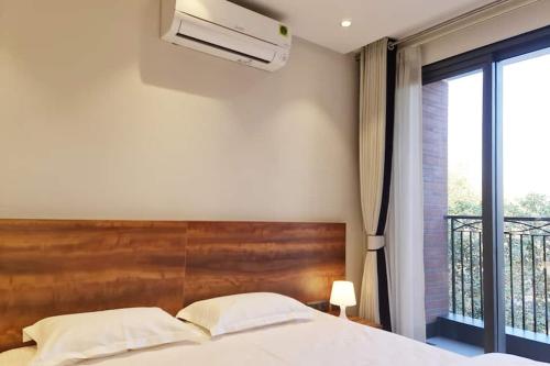 新德里Apt# ONE-FOUR-TWO - with Lift - High Speed Wifi - Smart TV的一间带大床的卧室和一个阳台