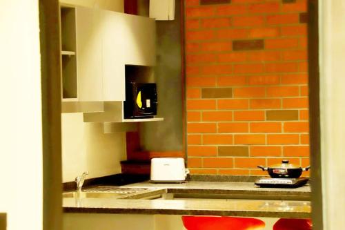 新德里Apt# ONE-FOUR-TWO - with Lift - High Speed Wifi - Smart TV的厨房配有水槽和台面