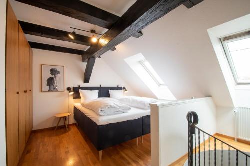 森讷堡Penthouse的阁楼上的卧室配有一张大床