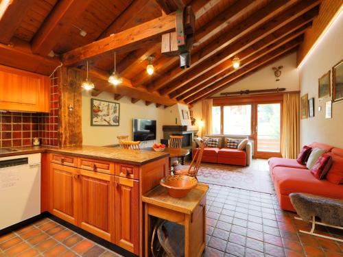 采尔马特Apartment Haus Rollin by Interhome的一间厨房和一间带红色沙发的客厅