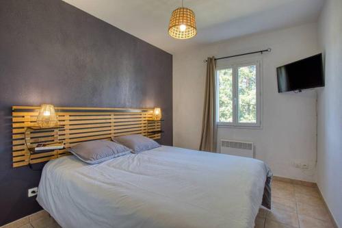 萨尔拉拉卡内达SARLAT - 24 - L'appartement d'Euphé avec piscine的一间卧室配有一张大床和电视