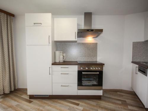 HochpillbergApartment Jägerhof-3 by Interhome的厨房配有白色橱柜和烤箱。
