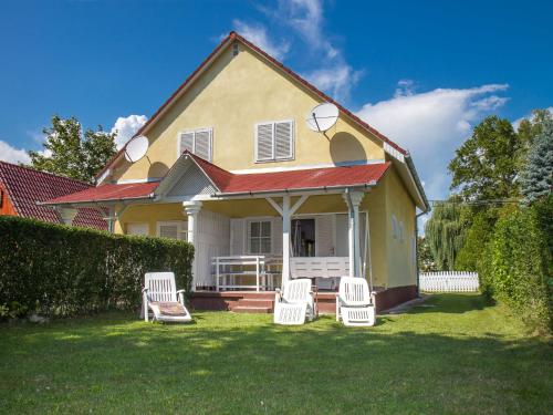 鲍洛通凯赖斯图尔Holiday Home Welle by Interhome的院子里有四把白色椅子的房子