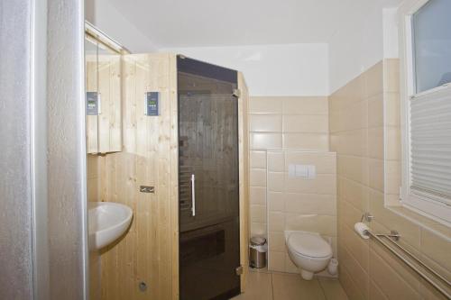 DrewoldkeFerienhaus Cumulus Haus - strandnah, Terrasse, Sauna的浴室配有卫生间、盥洗盆和淋浴。