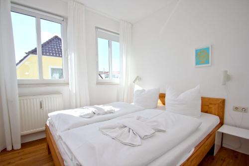 奥斯特巴德·哥伦Villa Linde FeWo 30 - Balkon的窗户客房内的一张白色床