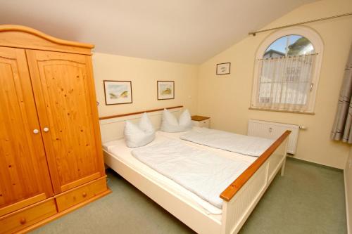 格洛韦Strandvilla Boeck Wohnung Nr 15的卧室配有白色的床和窗户。