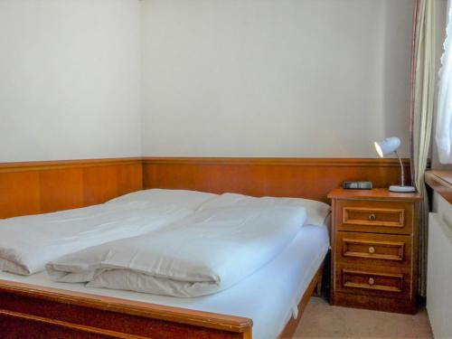 采尔马特Apartment by Interhome的床头柜旁的一张带木制床头板的床