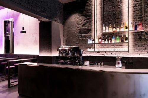 米兰Heart Hotel Milano的餐厅里的酒吧,带瓶子的柜台