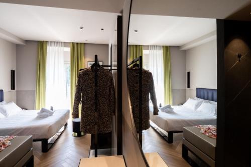米兰Heart Hotel Milano的酒店客房,设有两张床和镜子