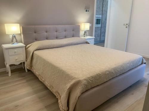 阿巴诺泰尔梅Appartamento Internazionale 2的一间卧室配有一张带2个床头柜的大床