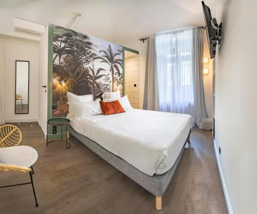 巴斯蒂亚Monsieur Miot Concept Hotel - Bastia centre的卧室配有一张大床,墙上挂有绘画作品