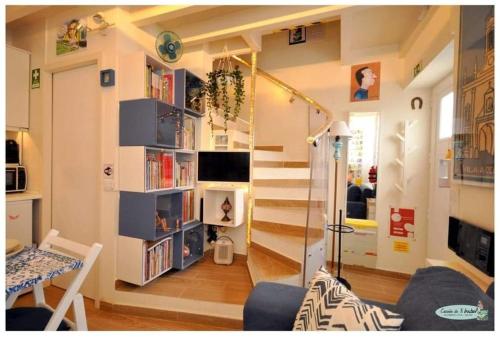 法鲁Casinha da Ti Babel的一间带书架楼梯的房间和一间客厅