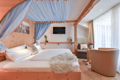 旧天鹅堡阿尔彭斯图本酒店的一间卧室配有一张带蓝色窗帘的大床