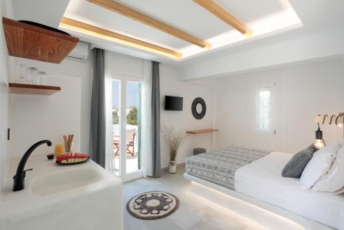 圣安娜纳克索斯Iades Studios & Apartments的一间白色卧室,配有一张床和浴缸