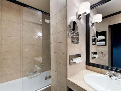 日内瓦Hotel Rotary Geneva - MGallery的一间带水槽和镜子的浴室