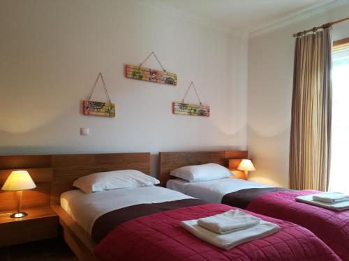 阿莫雷拉Praia Del Rey ViewPool Sea的紫色毯子,酒店客房内的两张床