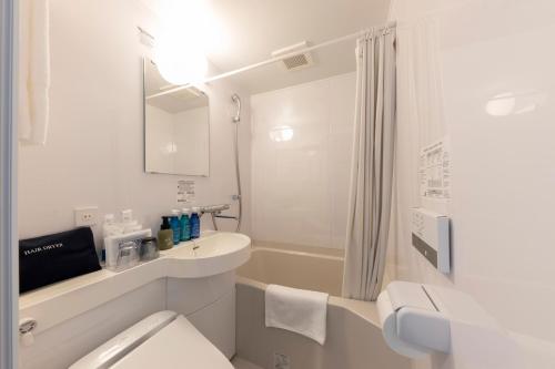 今治市JRクレメントイン今治的白色的浴室设有卫生间和水槽。