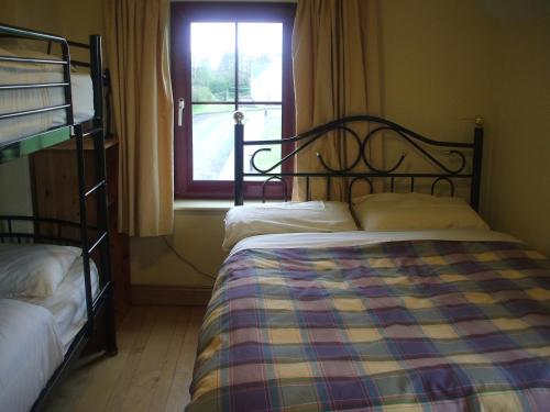Killeenleagh Bridge布鲁德罗玛德罗米旅馆的一间卧室设有两张双层床和一扇窗户。