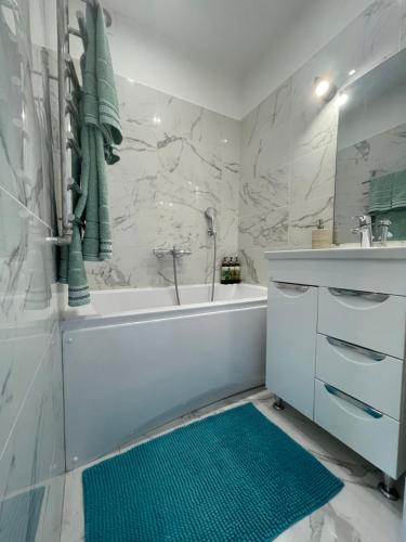 古尔贝内My Kingdom的浴室设有白色浴缸和绿色地毯。