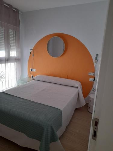 科尼尔-德拉弗龙特拉Hostal Casandra - antiguo Hostal Los Valencianos的一间卧室配有一张带橙色床头板的大床
