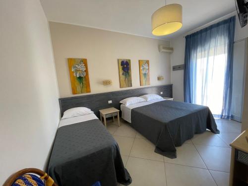 兰佩杜萨Albergo Moschella的酒店客房设有两张床和窗户。