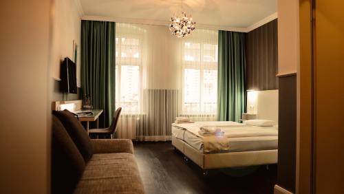 柏林柏林普恩斯酒店的酒店客房,配有床和沙发