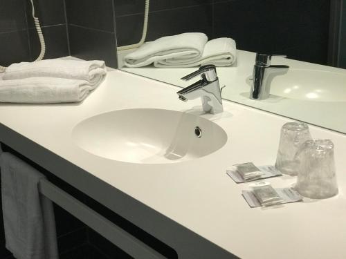 蒙马罗蒙特马罗尔快捷酒店 的浴室柜台配有白色水槽和毛巾