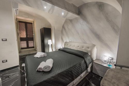 卡塔尼亚Suite Vico li cuti的一间卧室配有一张床,上面有两条毛巾