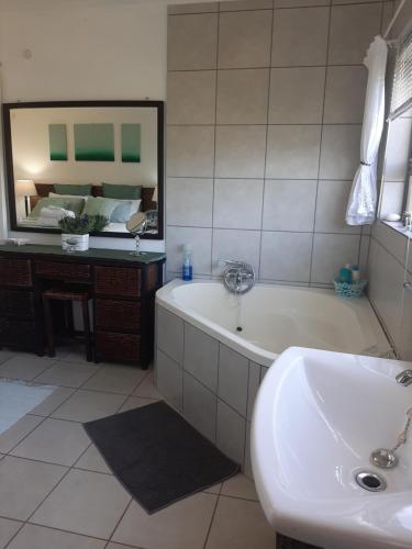 爱德华港Umtamvuna View Cabanas的带浴缸、水槽和镜子的浴室