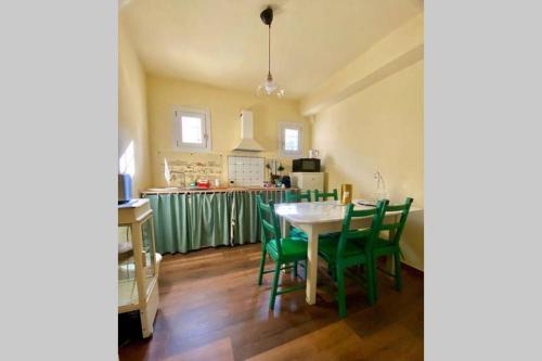 米拉Barchessa Ca’ Leon sul naviglio del Brenta的厨房以及带桌子和绿色椅子的用餐室。