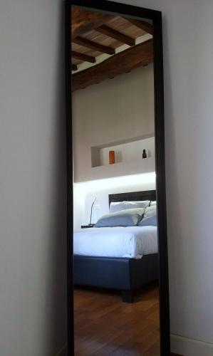圣吉米纳诺Contemporary Rooms的卧室的镜子反射,卧室内设有一张床