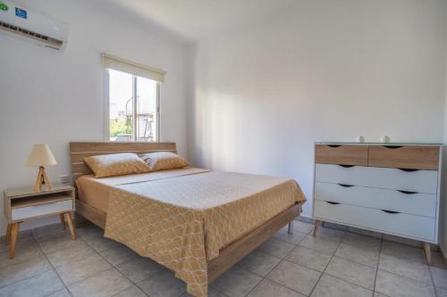 拉纳卡Downtown Larnaca的一间卧室配有一张床、一个梳妆台和一扇窗户。