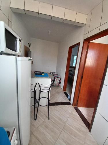 圣托梅-达斯莱特拉斯Apartamento avenida 06的厨房配有冰箱和带凳子的桌子