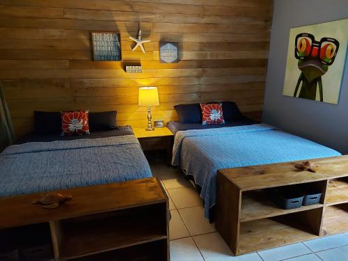 博卡斯德尔托罗Casa Oceana Bed & Breakfast的木墙客房的两张床