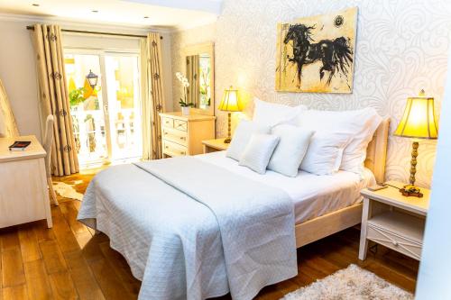 拉戈斯Resort Fazenda Viegas的卧室配有一张白色大床,墙上挂有马画